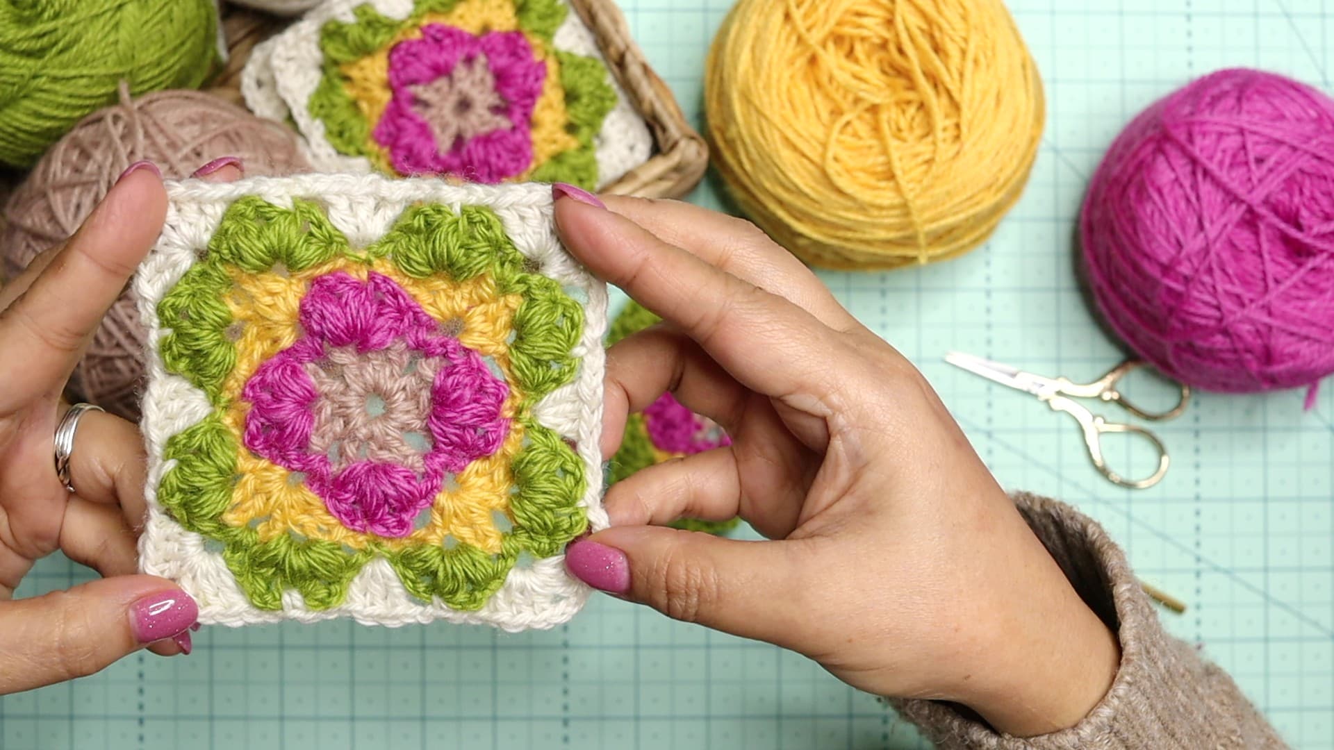 Elizabeth is holding and showing you a closer look of the Lotus shell granny square
