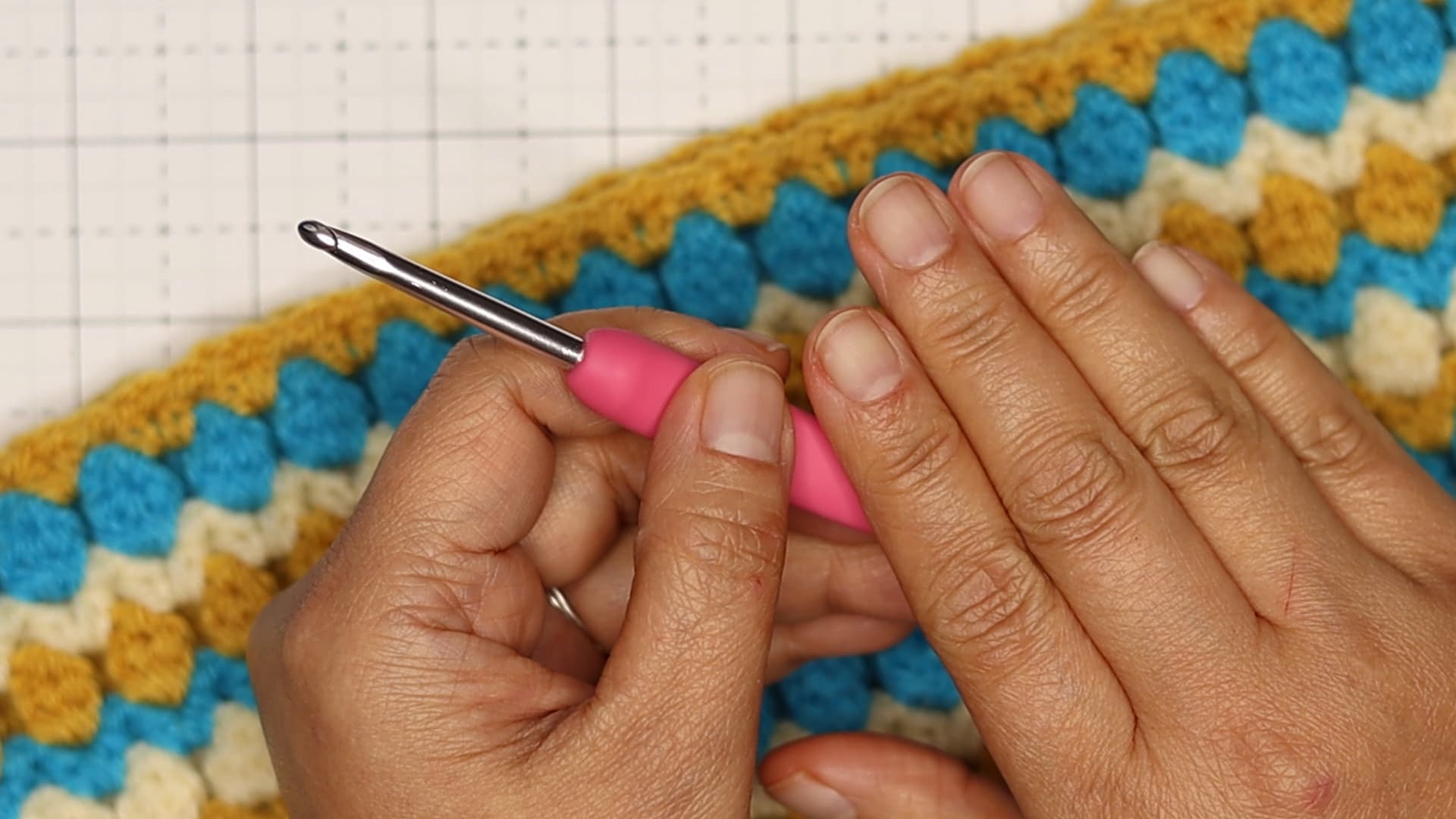 a picture of Beth's clean nails holding a pink crochet hook