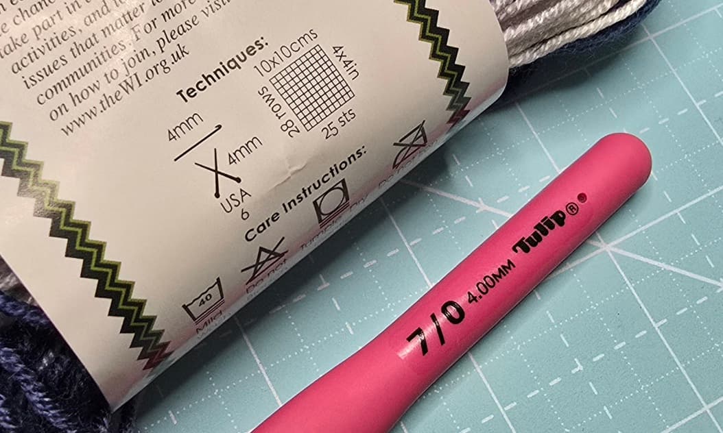 A partial image of yarn and hook showing in focus matching yarn hook size requirements