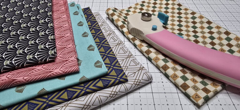 Beth is showing a couple of fat quarters fabric on her white cutting mat